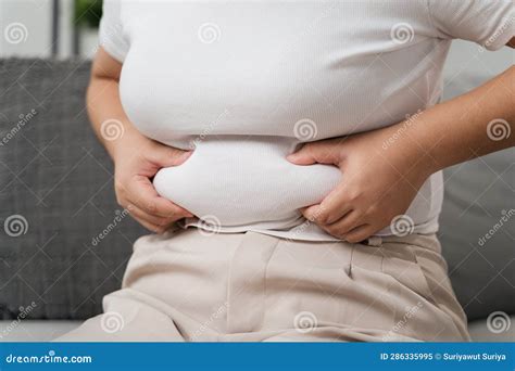 Close Up Of Chubby Woman Holding Her Belly Fat On The Sofa Diet