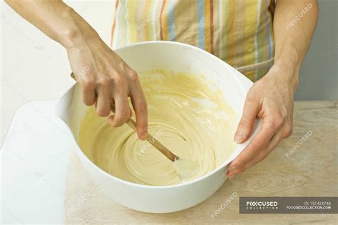 woman mixing batter   wooden spoon   bowl person meal stock photo