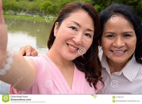 two mature asian women together relaxing at the park stock image image of couple japanese