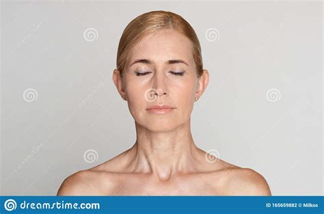beautiful middle aged woman with bare shoulders and closed eyes stock