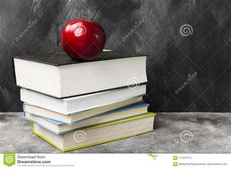 pile   books  red apple  dark background copy spa stock