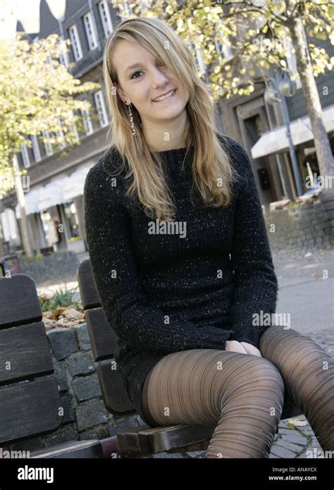 hübsche blonde frau mit minirock sitzen auf einer bank stockfotografie