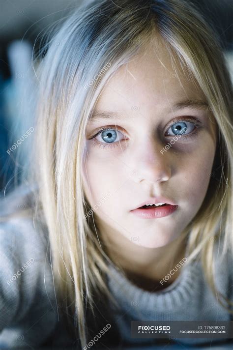 beautiful blonde preteen girl with big blue eyes looking