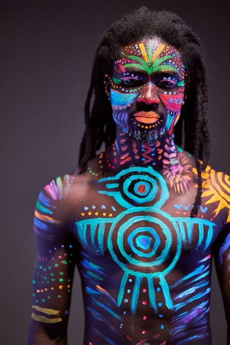 african man painted  fluorescent paint  face  muscular torso stock photo image
