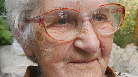 old woman in glasses looking forward and smiling portrait of happy