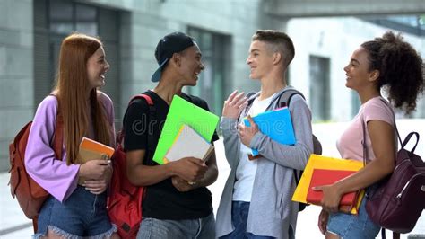 cheerful classmates  notebooks  backpacks walking campus