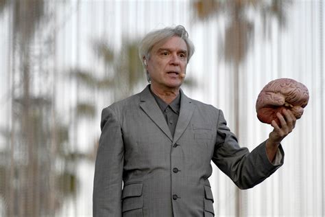 david byrne opens coachella set sitting at a table holding
