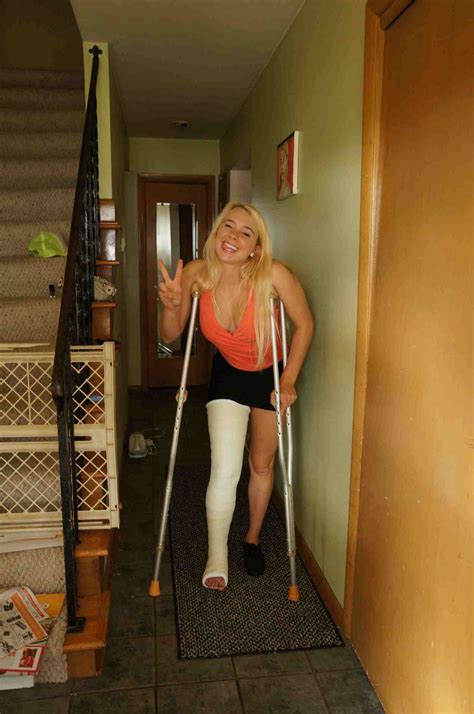 A Woman With Crutches Is Walking Up The Stairs And Holding Onto Her Leg