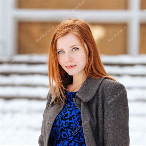 Closeup Portrait Of Young Adorable Redhead Woman In Blue Dress And Grey