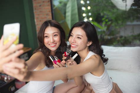 twee aziatische vrouwen die elkaar tegen witte achtergrond