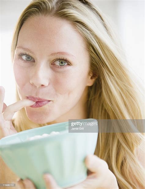 Woman Licking Her Finger Holding Bowl Of Dessert Bildbanksbilder