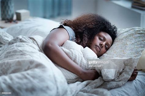 black woman sleeping in bed photo getty images