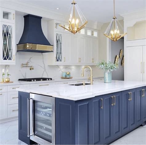 kitchen  white cabinets  blue island   center gold accents   hood