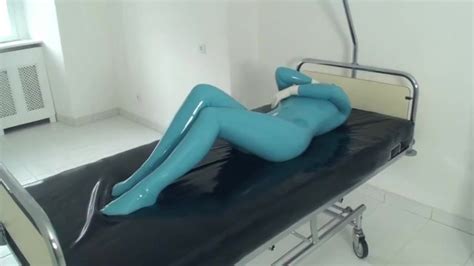 sexy girl full encased in blue latex catsuit condom mask and hard