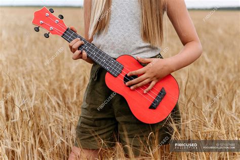 Girl Playing Guitar While Standing On Wheat Field — Hair People