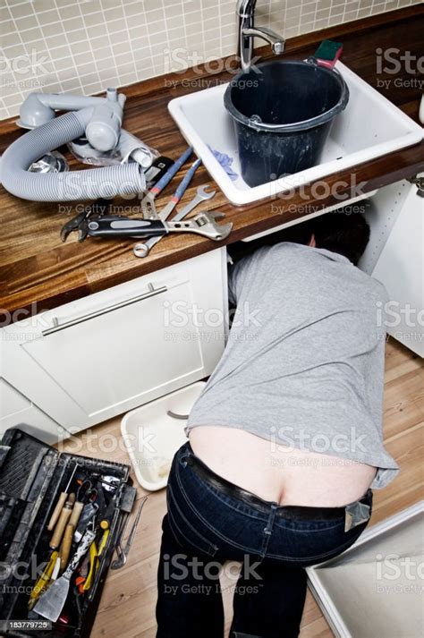 idraulico al lavoro sotto un lavello unità fotografie stock e altre