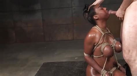 black slut on her knees and tied up with cock down her throat