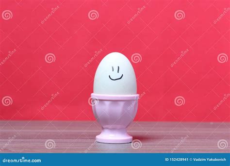 gekookt ei  gestroopt roze op ei geschilderde smiley tegen de achtergrond van koraalkleur