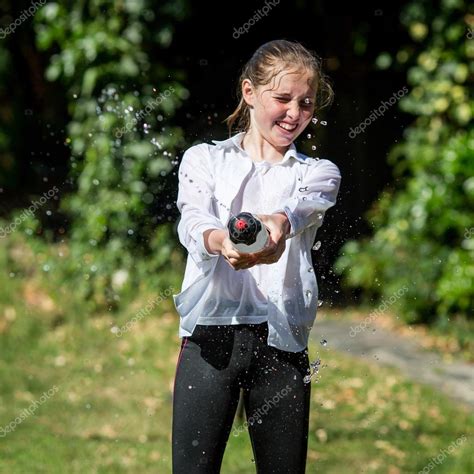 wet teenage girl squirts water from bottle — stock fotografie © heijo 80542430