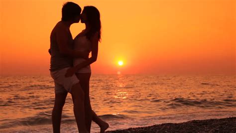 Romantic Teen Couple Kissing On The Beach At Sunset Stock