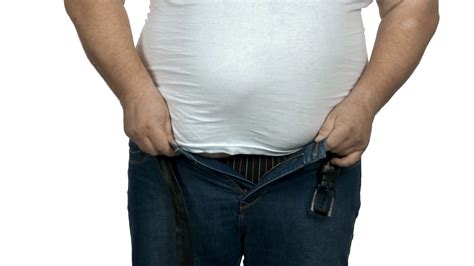fat guy trying to put on tight jeans obese man with big belly isolated