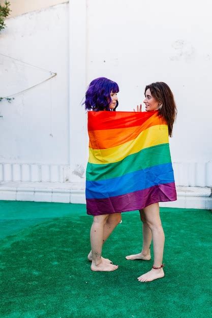 Premium Photo Side View Of Lesbian Couple Wearing Rainbow Flag Outdoors