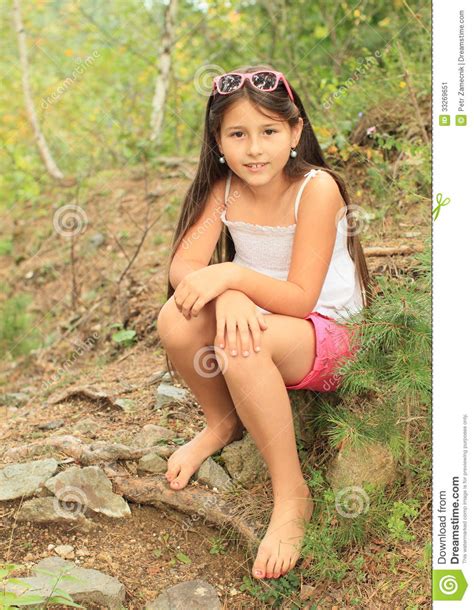 muchacha que se sienta en la tierra imagen de archivo