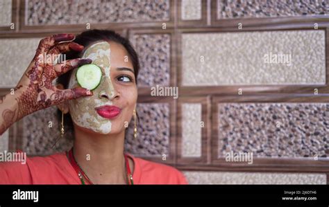 A Woman With Facial Mask And Fresh Cucumber On Eyes Relaxing At Home