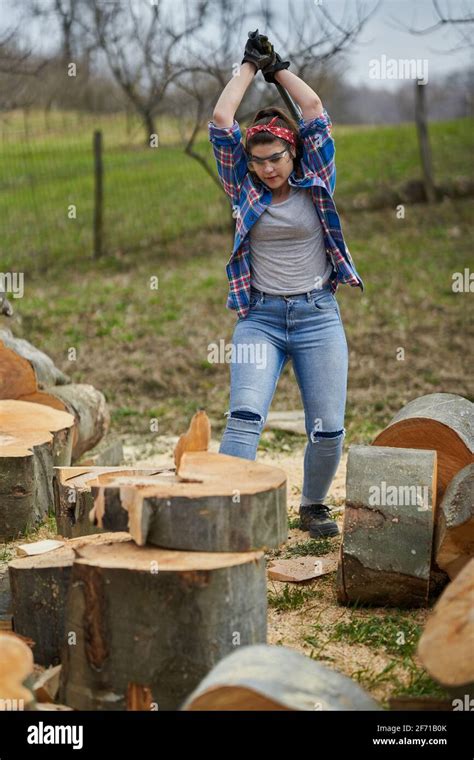 strong woman lumberjack   ax splitting beech logs stock photo