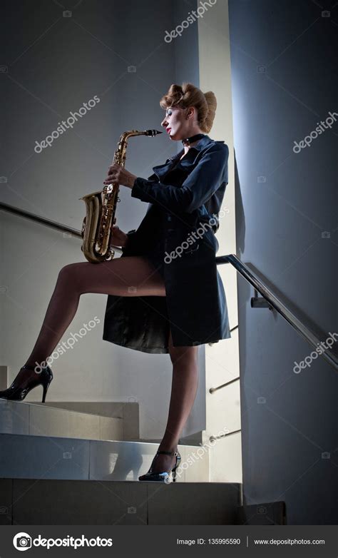 sexy attractive women with saxophone and long legs posing on stairs