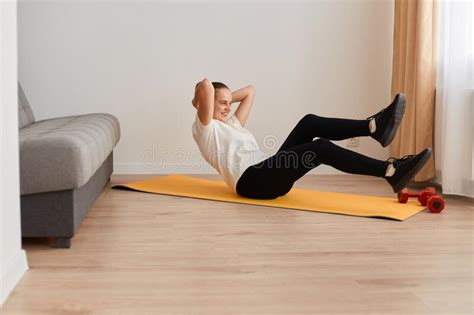 Fitness Determined Middle Aged Woman Lying Doing Crunches At Home On