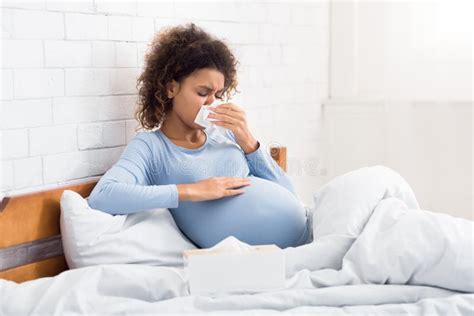 Pregnancy And Illness Sick Pregnant Woman Blowing Nose In Tissue
