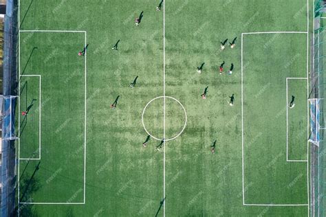 premium photo aerial view  soccer players playing football  green sports stadium