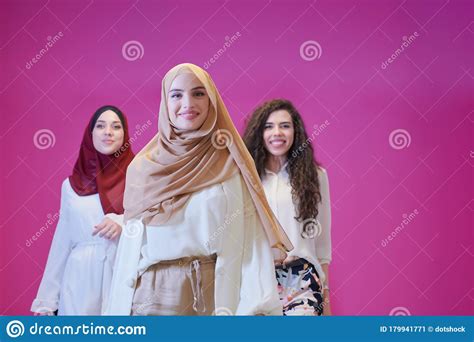 muslim women in fashionable dress isolated on pink stock
