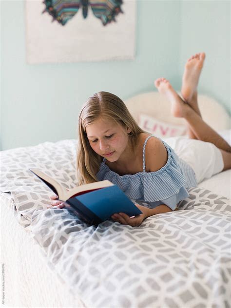 young girl reading   bed  stocksy contributor ali harper stocksy