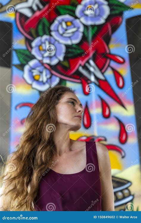 Lovely Brunette Model Posing Outdoors Against Graffiti Editorial