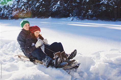 Young Couple Riding Sled In Deep Snow By Stocksy Contributor Tana