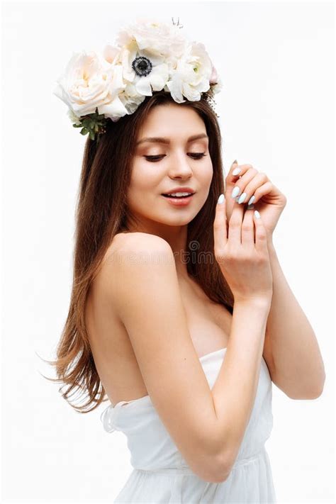 Beautiful Young Girl Smiling And Posing With Flowers On White