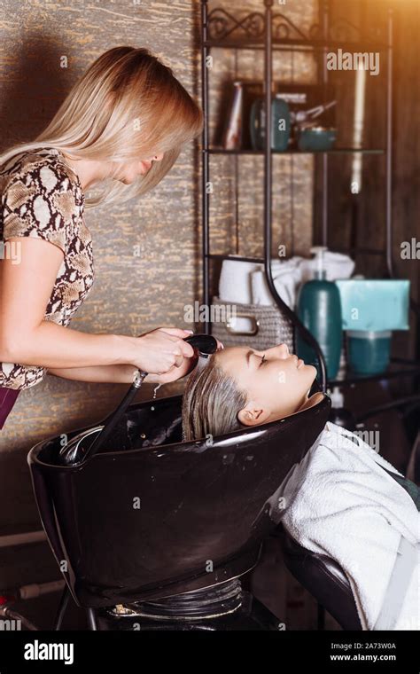 Beautiful Blonde Woman Hairdresser Washes Hair Clients In Hair Salon