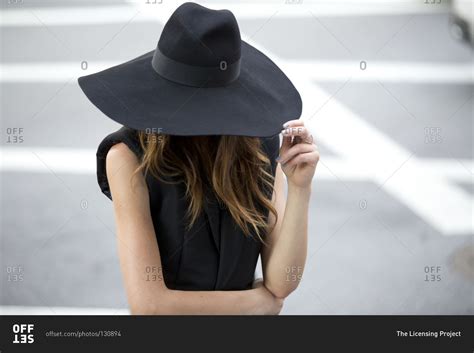 woman hiding face  wide brimmed hat stock photo offset