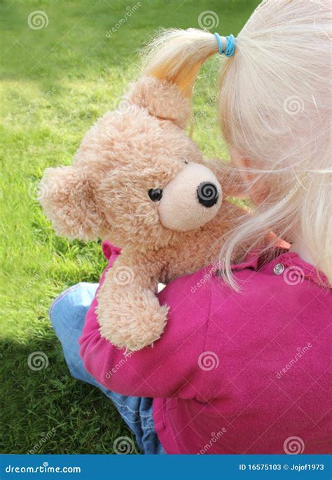 child cuddling teddy bear stock  image