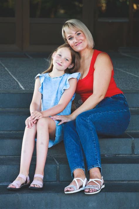 beautiful blonde mom in a red t shirt with her daughter group portrait