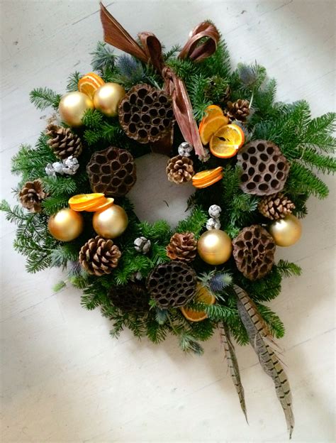 natural holiday wreath  baubles pine cones lotus seed heads dried oranges feathers www