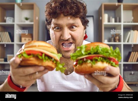 Hungry Chubby Man Looking At Two Delicious Hamburgers With Funny Face