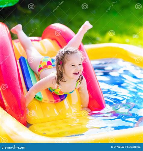 girl playing  inflatable garden swimming pool stock photo