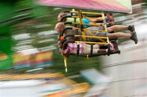 teens on a flying carnival ride motion blur editorial