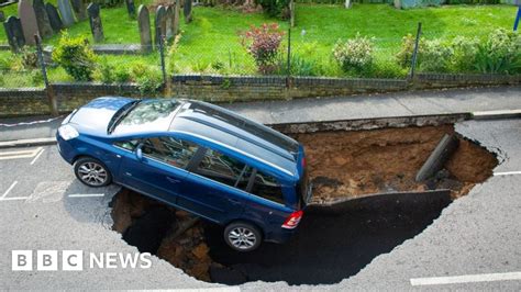 a car is swallowed by a large hole in the street in south london bbc