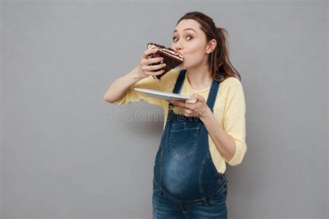 portrait of a hungry pregnant woman eating sweet chocolate