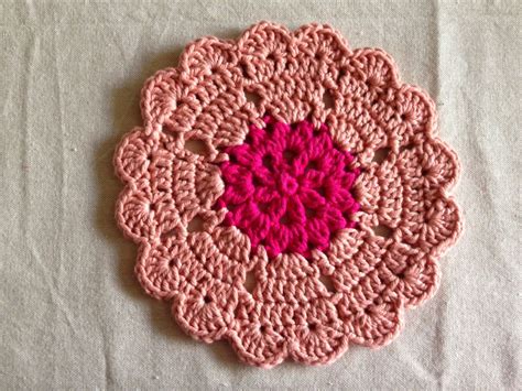 pink crocheted doily   red center   white tablecloth