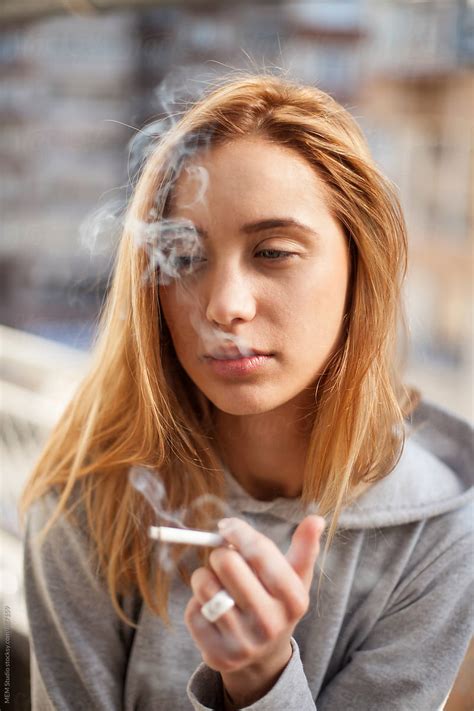 attractive young woman smoking cigarette  stocksy contributor mem